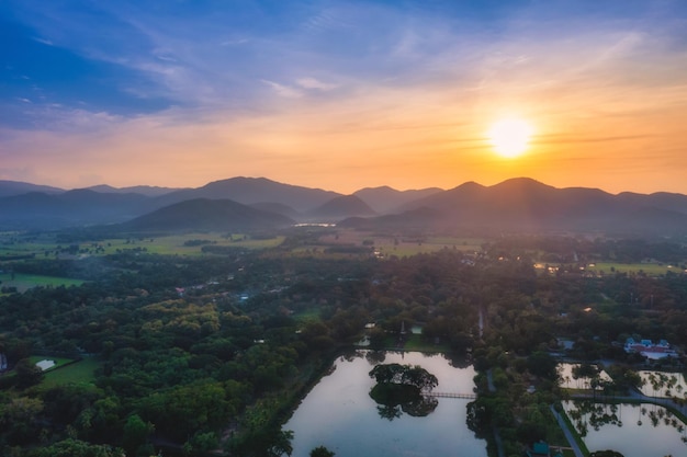 Aerial top view of mountains and tree at sunset with dramatic sky