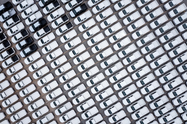 Aerial top view new cars lined up parked in a row in warehouse at the commercial dock for exporting