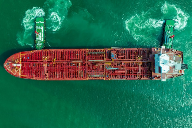 Вид сверху на нефтеналивное судно, красный нефтяной танкер на зеленом море