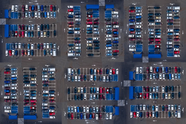 Photo aerial top view of parking with many cars. many cars are parked in a parking lot with white markings. parking places with vehicles pattern.