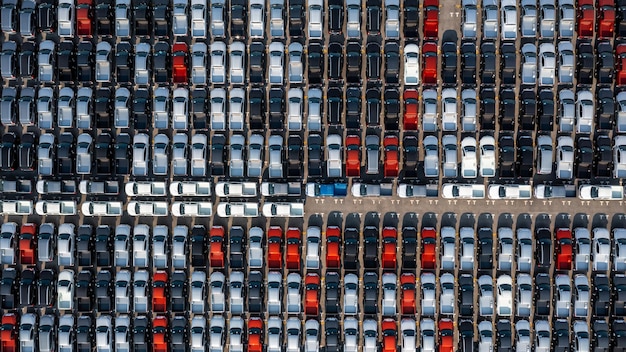 Aerial top view rows of new cars parked in distribution center
on car factory automobile and automotive car parking lot for
commercial business industry to dealership for sale