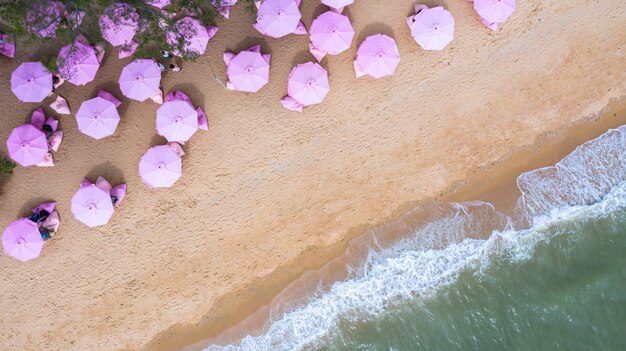 Aerial top view on the sandy beach. Pink umbrellas.