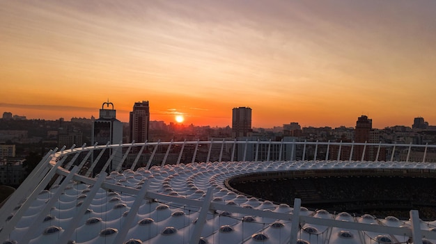 Aerial top view of stadium and Kyiv cityscape on sunset from above city of Kiev skyline Ukraine