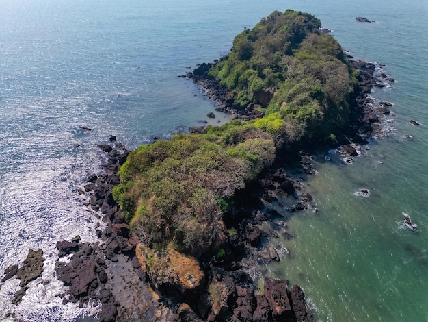 Aerial top view on tropical beach with green palm trees under sunlight Drone view in Goa