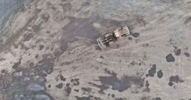 Aerial top view in work the excavator in an open pit the inside a granite quarry