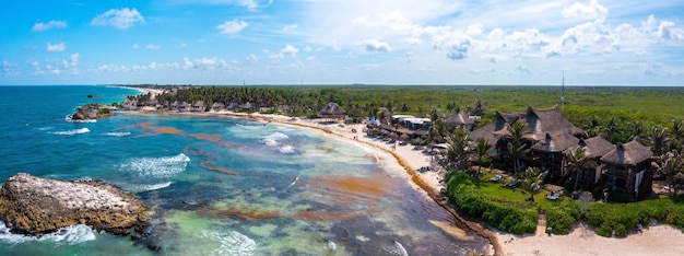 Воздушная береговая линия Тулума у пляжа с волшебным Карибским морем и небольшими хижинами у побережья. Прекрасная природа Тулума. Вид с воздуха на Мексику.