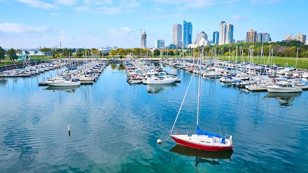 Aerial Vibrant Marina met rode zeilboot en stedelijke skyline