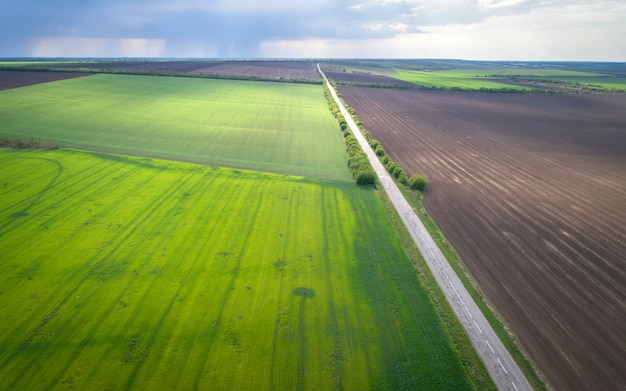 Aerial view of agricultural fields and road. Rainy weather.