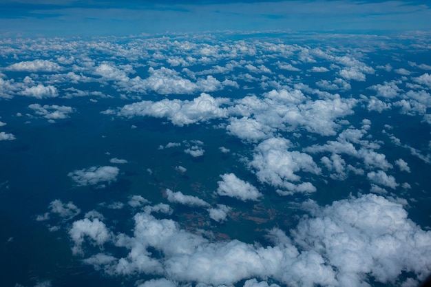 Aerial view of an airplane flying above clouds and sky View from the plane window