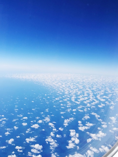 Aerial view of airplane wing against clear blue sky