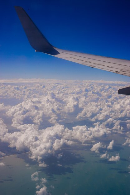 Aerial view of airplane wing over clouds