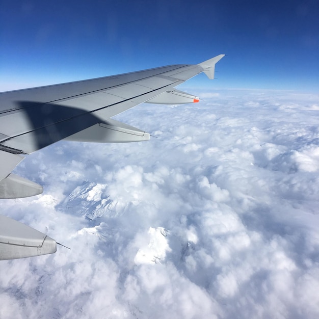 Aerial view of airplane wing over cloudscape