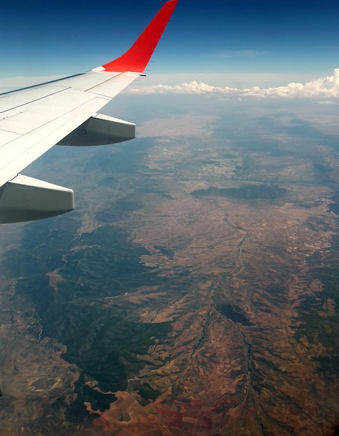 Foto vista aerea dell'ala di un aereo sopra il paesaggio