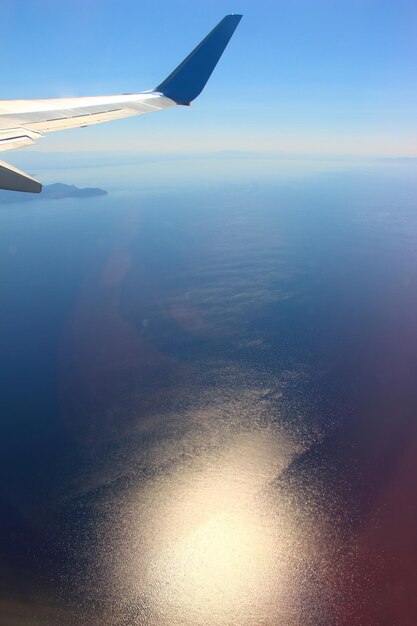 Aerial view of airplane wing over sea