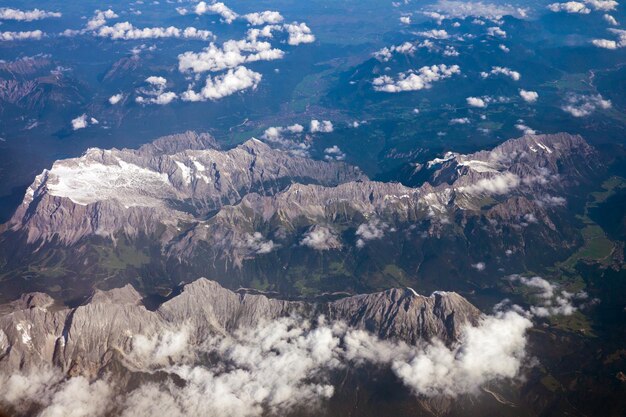 Photo aerial view of alps mountains with snow on mountain peaks seen from an airplane