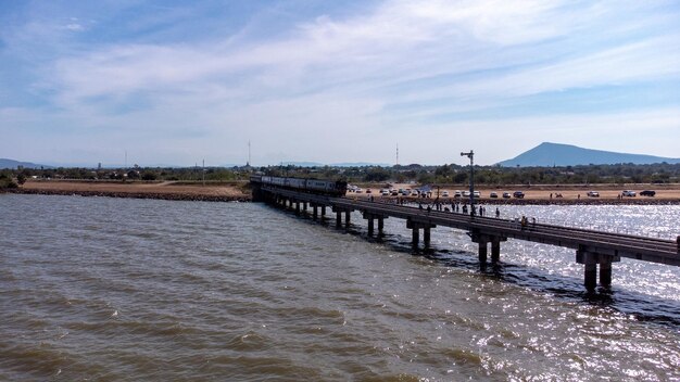 Aerial view of an amazing travel train parked on a floating railway bridge over the water