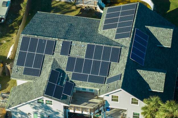청정 생태적 전기 에너지를 생산하기 위해 파란색 태양광 광전 패널이있는 미국 주택 지붕의 공중 사진 은퇴 소득을 위해 재생 가능한 전기에 투자