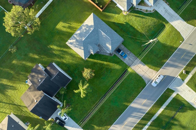 Aerial view of american small town in Florida with private homes between green palm trees and suburban streets in quiet residential area