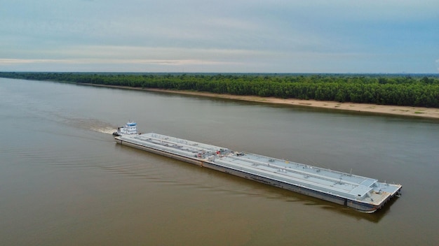 Aerial view of a barge on the Mississippi river with a blue sky in the background