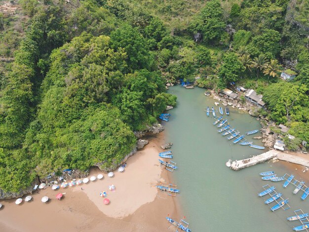 Aerial view of Baron beach in Yogyakarta Indonesia with lighthouse and traditional boats