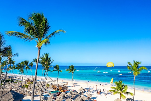 Aerial view of Bavaro beach Punta Cana tropical resort in Dominican Republic. Beautiful atlantic tropical beach with palms, umbrellas and parasailing balloon.