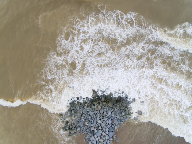 Aerial view of a beach with wave rocks and wave breaker