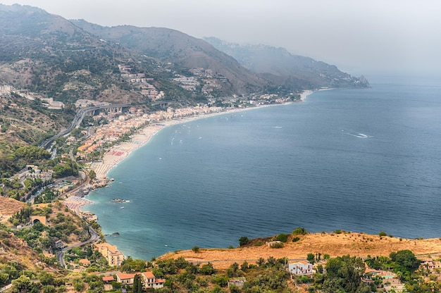 イタリア、シチリア島で最も訪問された観光スポットの1つであるタオルミーナの美しい海岸線の空撮