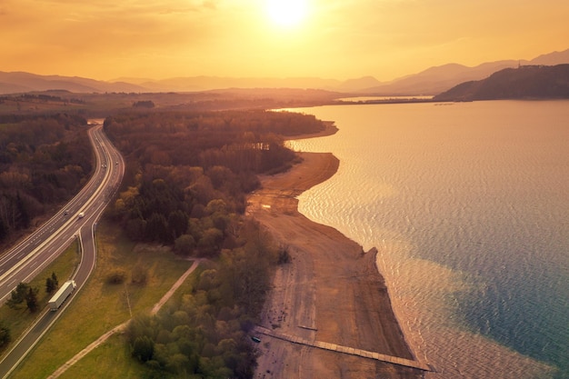 Vista aerea del bellissimo lago circondato da montagne e autostrada all'inizio della primavera durante il tramonto mare di liptov repubblica slovacca europa