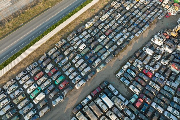 Aerial view of big parking lot of junkyard with rows of discarded broken cars Recycling of old vehicles