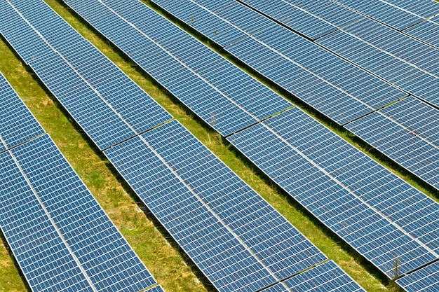 Aerial view of big sustainable electric power plant with many\
rows of solar photovoltaic panels for producing clean electrical\
energy renewable electricity with zero emission concept