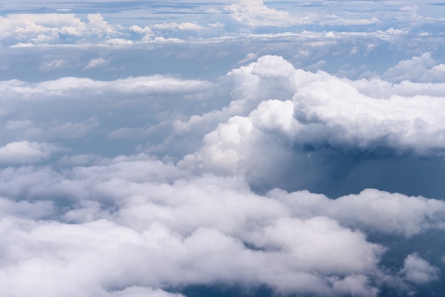 Vista aerea di grandi nuvole bianche e nuvole di pioggia su cielo blu sopra l'oceano blu