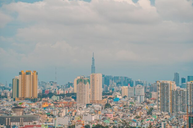 Aerial view of bitexco tower buildings roads vo van kiet road\
in ho chi minh city far away is landmark 81 skyscraper travel\
concept