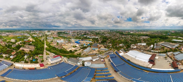 Aerial view of blue photovoltaic solar panels mounted on industrial building roof for producing clean ecological electricity. production of renewable energy concept.