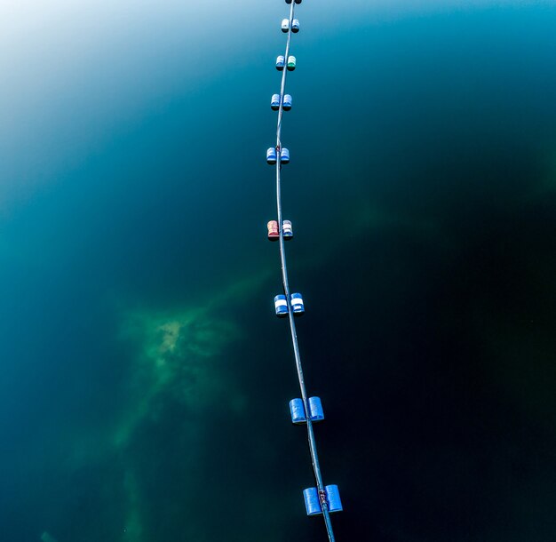 Photo aerial view of blue tube with barrels on the lake