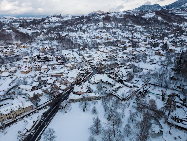 Aerial view of Bran city covered with snow in winter Romania