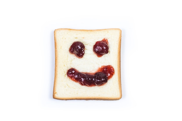 Aerial view of bright red strawberry preserves, spread over a slice of white bread