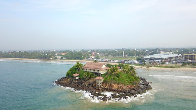 Photo aerial view of buildings by sea against sky