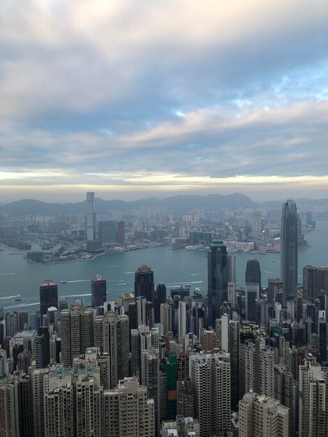 Aerial view of buildings in city against cloudy sky