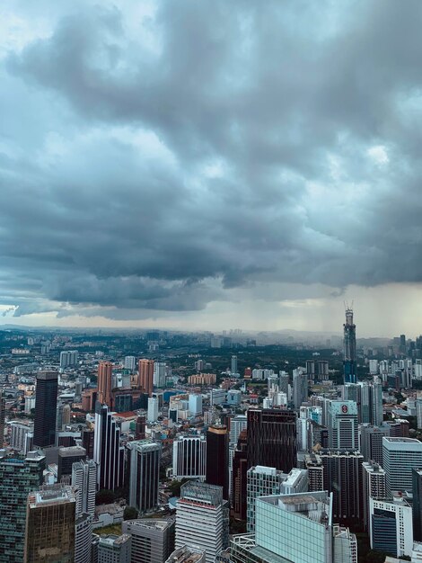 Aerial view of buildings in city against storm clouds