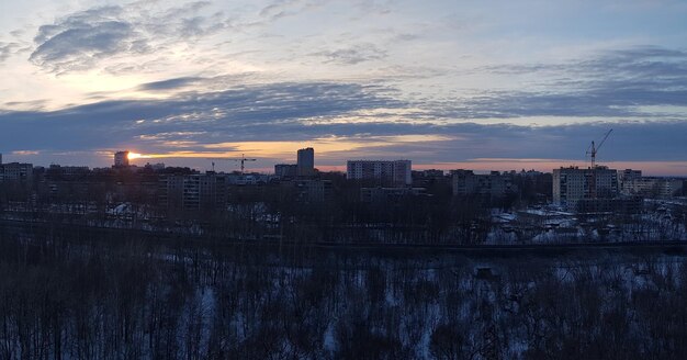 Aerial view of buildings in city at sunset