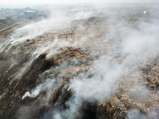 埋め立て地で燃えているゴミの山を上空から見た写真