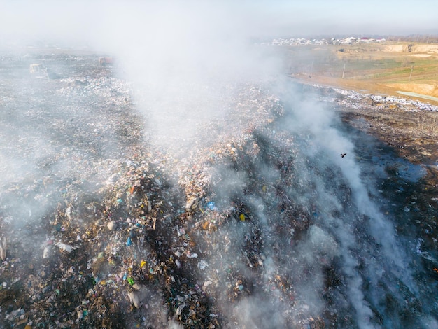 Photo aerial view of burning trash piles in landfill