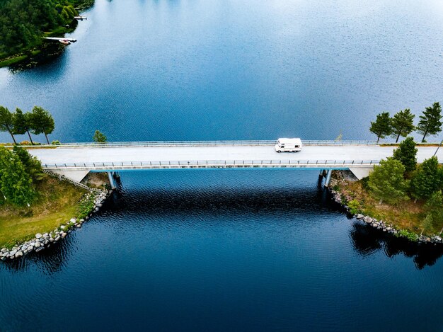 Aerial view Caravan trailer or Camper rv on the bridge over the lake in Finland Summer holiday trip