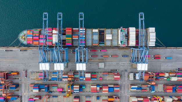 Aerial view cargo ship terminal, Unloading crane of cargo ship terminal, Aerial view industrial port with containers and container ship.