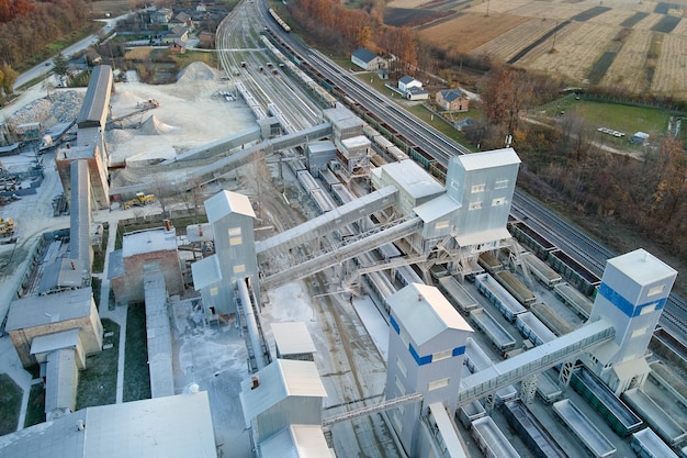 Vista aerea del treno merci caricato con materiali lapidei frantumati presso la fabbrica mineraria trasporto ferroviario di minerale calcareo macinato