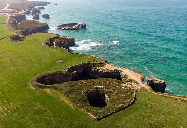 Aerial view cathedrals beach with green fields and blue sea, Galicia, Lugo , Spain