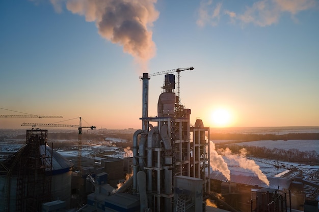 Aerial view of cement factory tower with high concrete plant structure at industrial production area at sunset Manufacturing and global industry concept