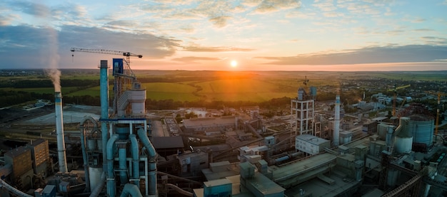 Vista aerea della fabbrica di cemento con struttura in calcestruzzo alta e gru a torre nell'area di produzione industriale. produzione e concetto di industria globale.