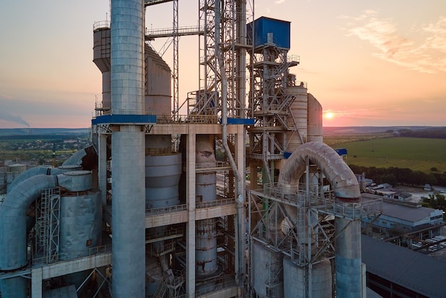 산업 생산 현장 제조 및 글로벌 산업 개념에서 높은 콘크리트 플랜트 구조와 타워 크레인이 있는 시멘트 공장의 항공 보기