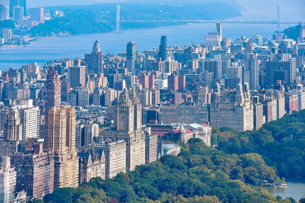 Foto vista aerea di central park e fila di edifici nell'upper west side. sullo sfondo il fiume hudson e il ponte george washington. manhattan, new york, stati uniti.